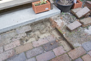 固まる土の舗装を剥がしてレンガを取り除きます
